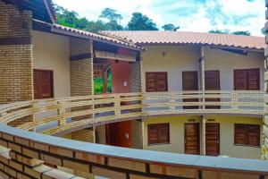 einen Balkon eines Hauses mit einer Holzterrasse in der Unterkunft Ap Classic - Pousada Flor da Serra - Mulungu in Mulungu