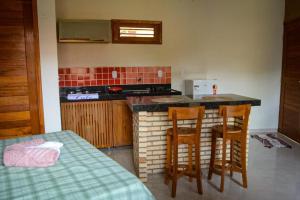 eine Küche mit einem Tisch, Stühlen und einer Arbeitsplatte in der Unterkunft Ap Classic - Pousada Flor da Serra - Mulungu in Mulungu