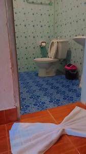 a bathroom with a toilet and a blue floor at Poonsap Resort in Ko Lanta