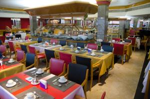 Un restaurante con mesas y sillas y un buffet. en Da Vinci Hotel & Conventions by Easy Hotéis, en Manaus