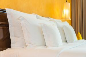 una pila de almohadas blancas sentadas en una cama en FINTUPS SPA, en Viña del Mar