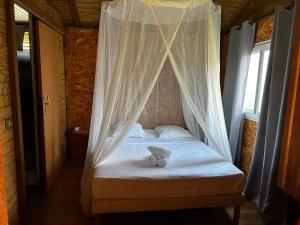 una cama con un osito de peluche sentado encima en Gîtes Hotel Couleur Caraibes, en Bouillante