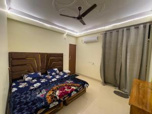 a bedroom with a bed and a ceiling fan at Cozzy Inn in Bhauli