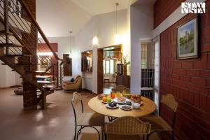 uma sala de jantar com uma mesa com fruta em StayVista at Golden Crest - Pet Friendly Villa with Breakfast em Mysore