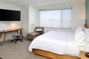 a hotel room with a bed and a desk at Element North Kansas City in Kansas City