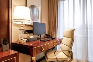 a room with a desk with a computer and a chair at 潍坊富华大酒店a座 in Weifang