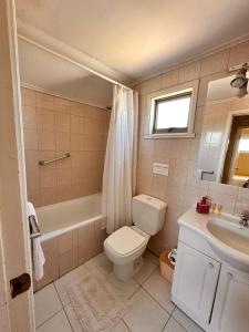 Un baño con inodoro, bañera y lavabo. en Apart hotel Terra Valdivia, en Valdivia