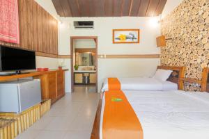 a hotel room with two beds and a flat screen tv at Green Asri Hotel in Senggigi 