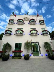 een hoog wit gebouw met bloembakken en ramen bij Royal Madero Inn Express in Tampico