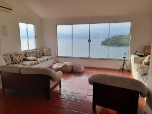 安格拉杜斯雷斯的住宿－Casa Grega em Angra dos Reis com Piscina e Vista Espetacular，客厅设有两张沙发和一个大窗户