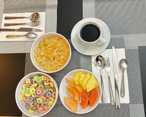 a table with three plates of food and a cup of coffee at Royal Madero Inn Express in Tampico
