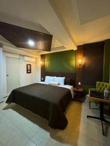 a bedroom with a large bed and a desk at Royal Madero Inn Express in Tampico