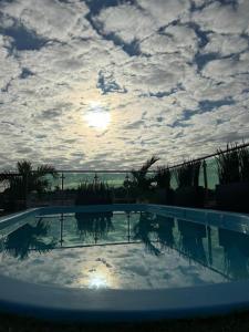 a swimming pool with a cloudy sky in the background at Royal Madero Inn Express in Tampico
