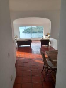 a room with chairs and a table and a large window at Casa Grega em Angra dos Reis com Piscina e Vista Espetacular in Angra dos Reis