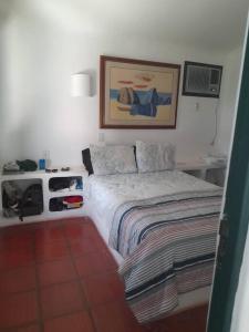 a bedroom with a bed and a picture on the wall at Casa Grega em Angra dos Reis com Piscina e Vista Espetacular in Angra dos Reis