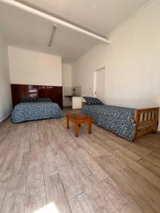 a room with two beds and a wooden floor at Neco Calle 16 in Necochea