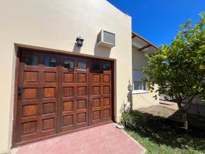 a wooden garage door on a house with a tree at Neco Calle 16 in Necochea