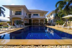 une maison avec une piscine en face d'une maison dans l'établissement Luxurious 5-Bedroom Private Pool Villa! PV5, à Hua Hin