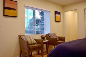 a bedroom with two chairs and a table and a window at Hollywood Hills Haven-Guest House in Los Angeles