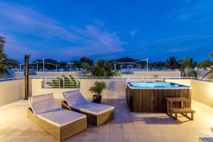 a patio with two chairs and a hot tub on a balcony at Oriental Beach Pearl Resort in Sam Roi Yot