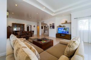 - un salon avec un canapé et une télévision dans l'établissement Luxurious 5-Bedroom Private Pool Villa! PV5, à Hua Hin