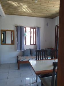 una sala de estar con una mesa y un sofá en Casas do Manoel, en Praia do Rosa