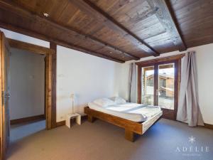 een slaapkamer met een bed en een groot raam bij Appartement Montvalezan-La Rosière, 3 pièces, 6 personnes - FR-1-398-661 in Montvalezan