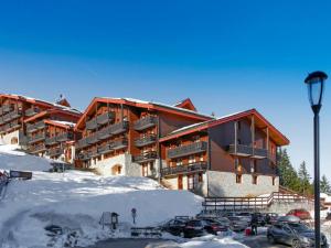 a large building with cars parked in the snow at Appartement Courchevel 1550, 2 pièces, 4 personnes - FR-1-575-210 in Courchevel