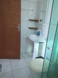 a bathroom with a toilet and a sink at Casas do Manoel in Praia do Rosa