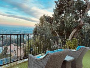 a balcony with two chairs and a view of the city at Hollywood Hills Haven-Guest House in Los Angeles