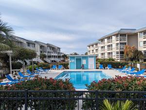 a swimming pool with lounge chairs and a resort at Harbor Island D112 in Oceanmarsh Subdivision