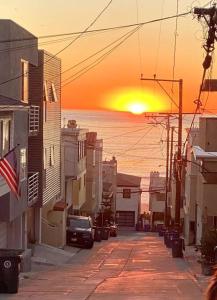 una calle de la ciudad con la puesta de sol en la distancia en Beach Gateway Full Kitchen 1 Bedroom Duplex, en Manhattan Beach