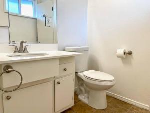 y baño con aseo, lavabo y espejo. en Beach Gateway Full Kitchen 1 Bedroom Duplex, en Manhattan Beach