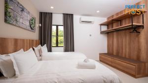 a hotel room with two beds with white sheets at Damai Laut Escape by Perfect Host in Lumut