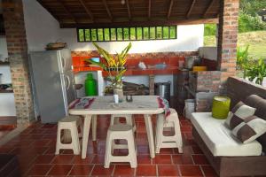 patio con mesa, sillas y nevera en Cabaña el Gaque en Curití