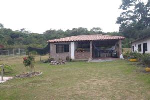 ein kleines Backsteinhaus mit Hängematte im Hof in der Unterkunft Cabaña el Gaque in Curití