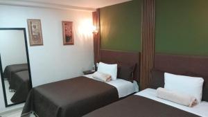 Cette chambre comprend 2 lits et un miroir. dans l'établissement Royal Madero Inn Express, à Tampico