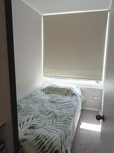 uma pequena cama num quarto com uma janela em Suitsebastian em Temuco