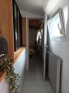 un couloir menant à une chambre avec fenêtre dans l'établissement Chambre cosy et salle d'eau dans maison Mérignac Arlac, à Mérignac