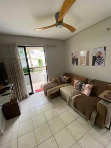 Una sala de estar con un sofá y un ventilador de techo. en Apartamento em Florianópolis, en Florianópolis