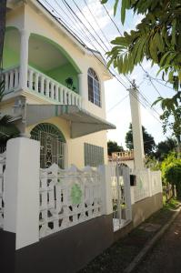une clôture blanche devant une maison dans l'établissement Aileen Palm Cove Ja, à Ocho Rios