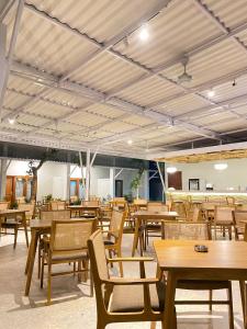 um restaurante vazio com mesas e cadeiras de madeira em Maluk Stay em Maluk
