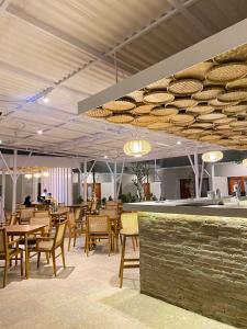 un ristorante con tavoli e sedie in legno e luci di Maluk Stay a Maluk