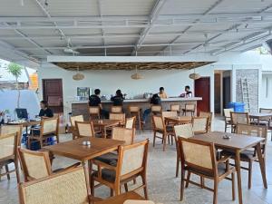 a restaurant with tables and people sitting at a counter at Maluk Stay in Maluk