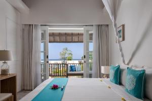 een slaapkamer met een bed en uitzicht op de oceaan bij Kardia Resort Gili Trawangan A Pramana Experience in Gili Trawangan