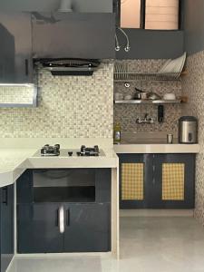 a kitchen with black and white counters and a stove at The Retreat in Jhunjhunūn