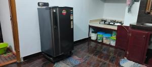 a kitchen with a black refrigerator in a room at Vibgyor Home away from Home in Kānnangād