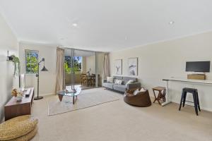 uma sala de estar com um sofá e uma mesa em Modern 2BR Apt next to SouthBank Free Wifi & Pool em Brisbane