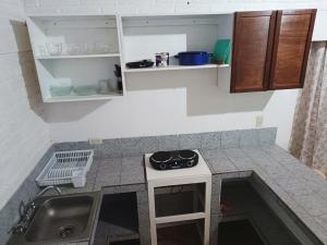 a small kitchen with a sink and a stove at La Casita de Cayita in La Peñita de Jaltemba