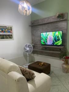 a living room with a couch and a flat screen tv at Cantinho do amor in Vitória